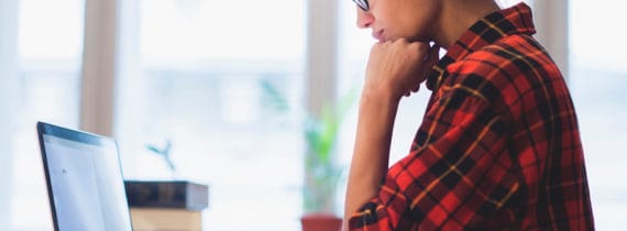 Woman seated with a laptop on a desk