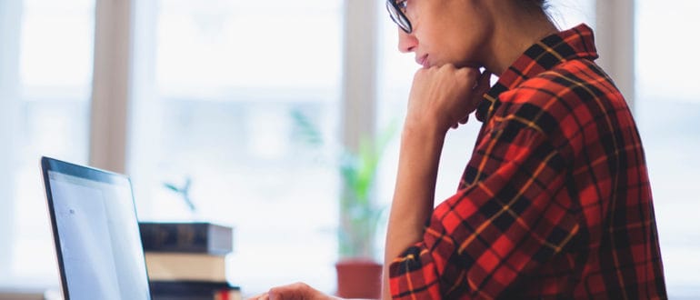 Woman seated with a laptop on a desk