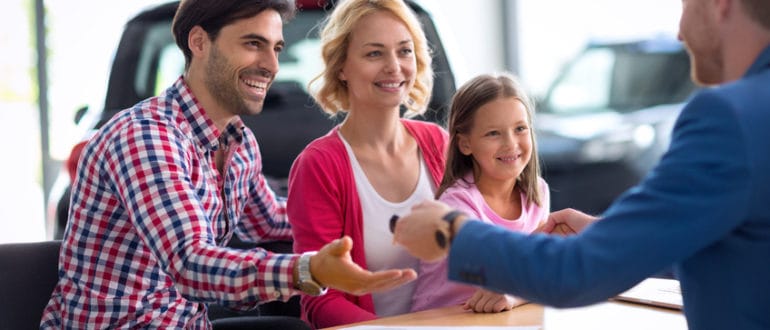 family buying a new car from a dealer