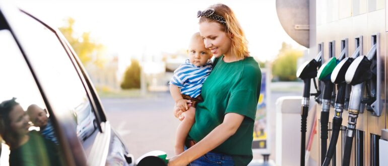 A woman holding a baby at a gas station