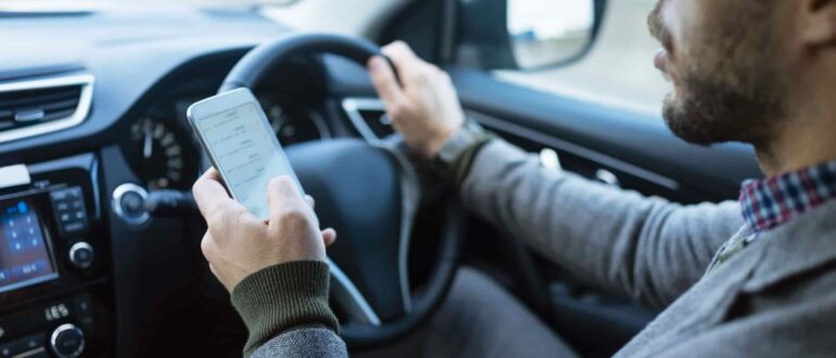A man driving while using a phone