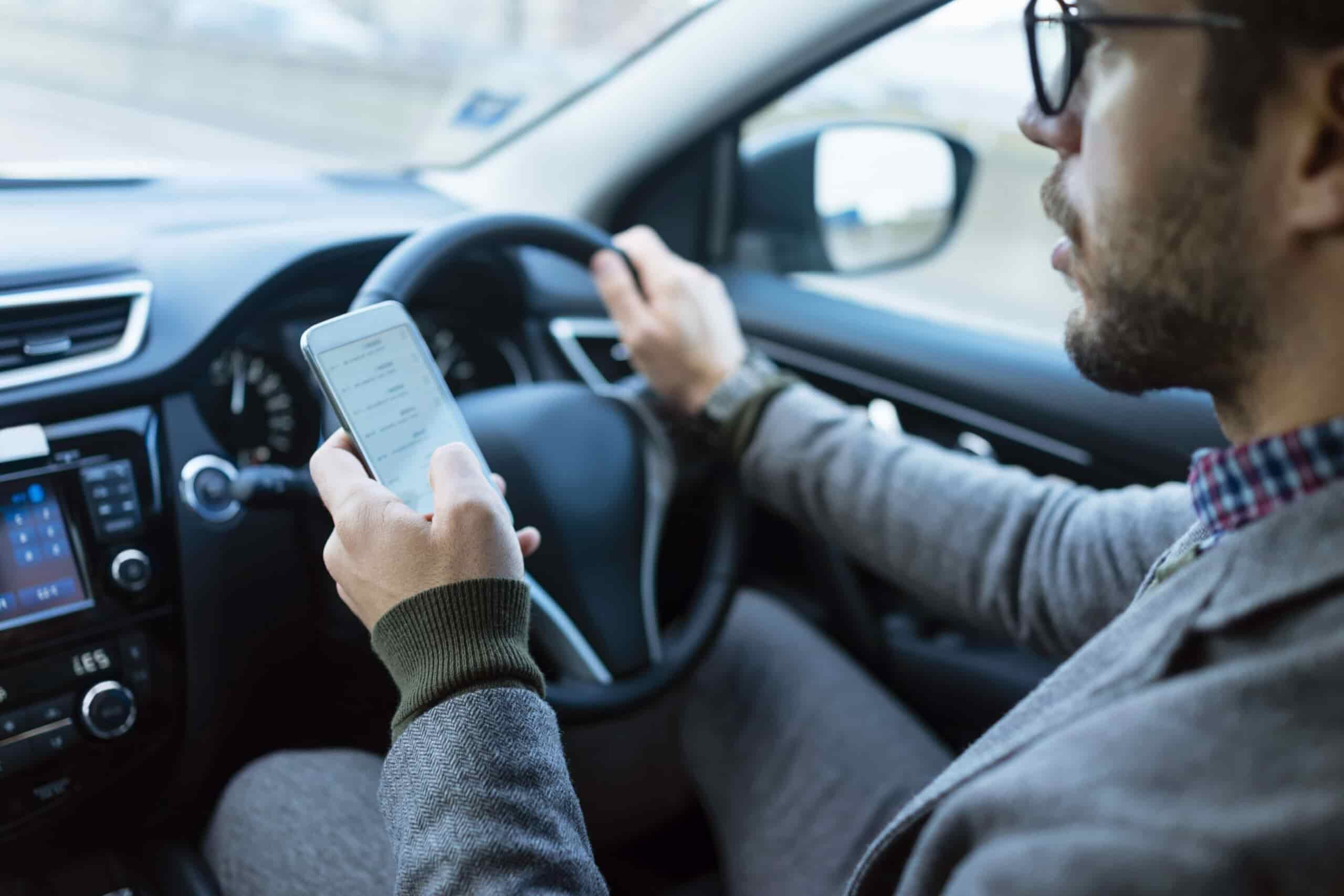 A man driving while using a phone