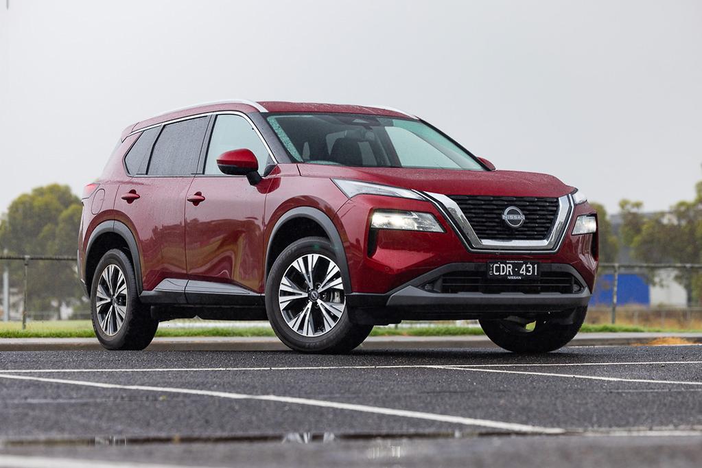 red suv: nissan x-trail parked on grey pavement