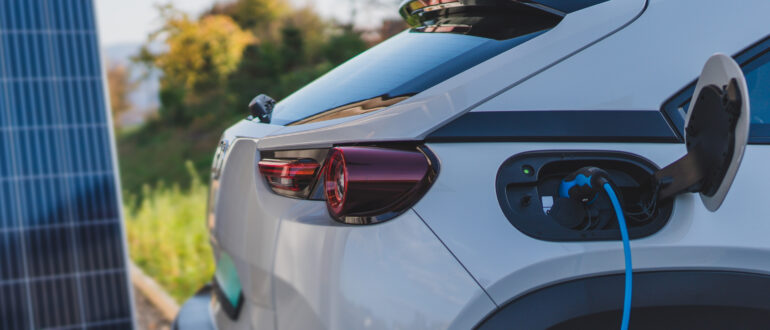 close up of an electric grey car being charged